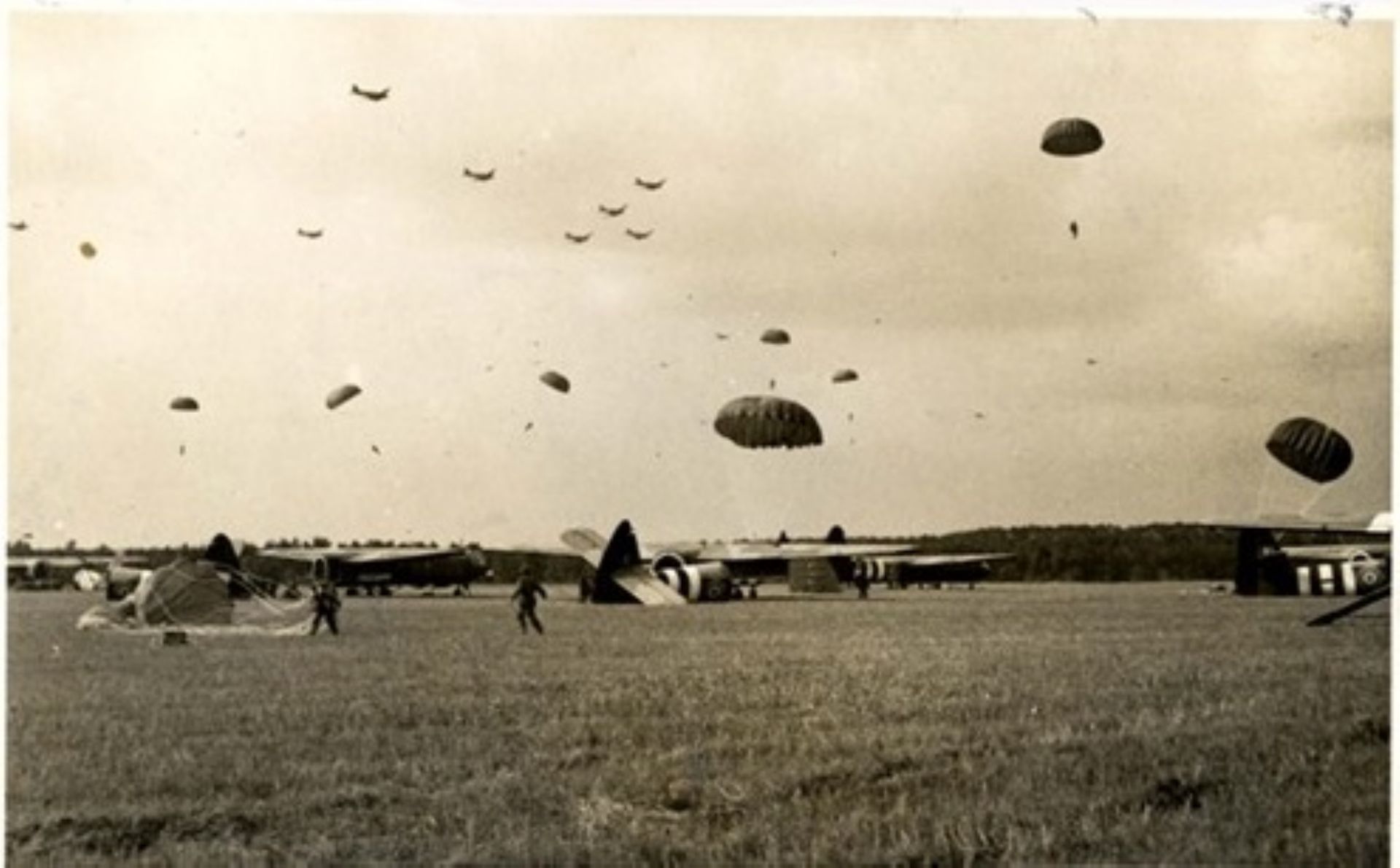 Parachutisten zijn uit het vliegtuig gesprongen en zweven naar beneden.